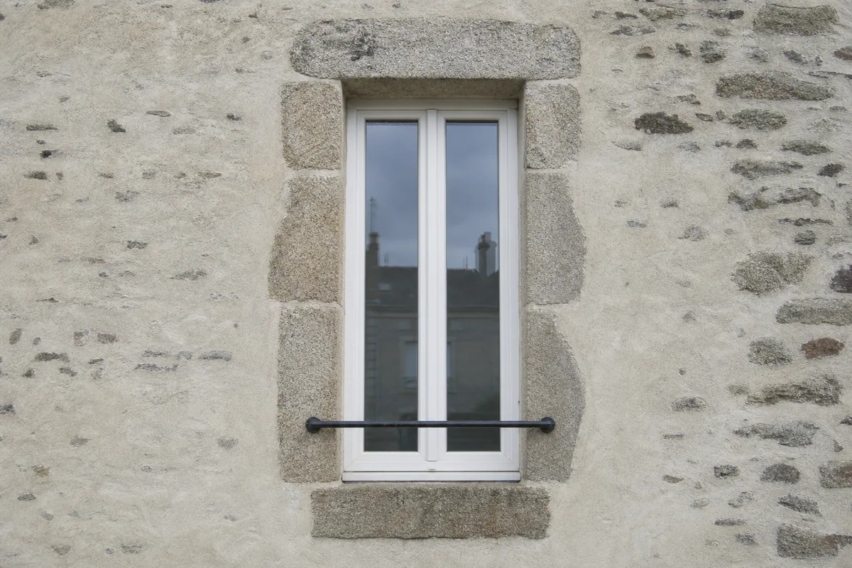 Façade de maison de ville en moellon enduit à Saint-Junien avec ses fenêtres verticales étroites